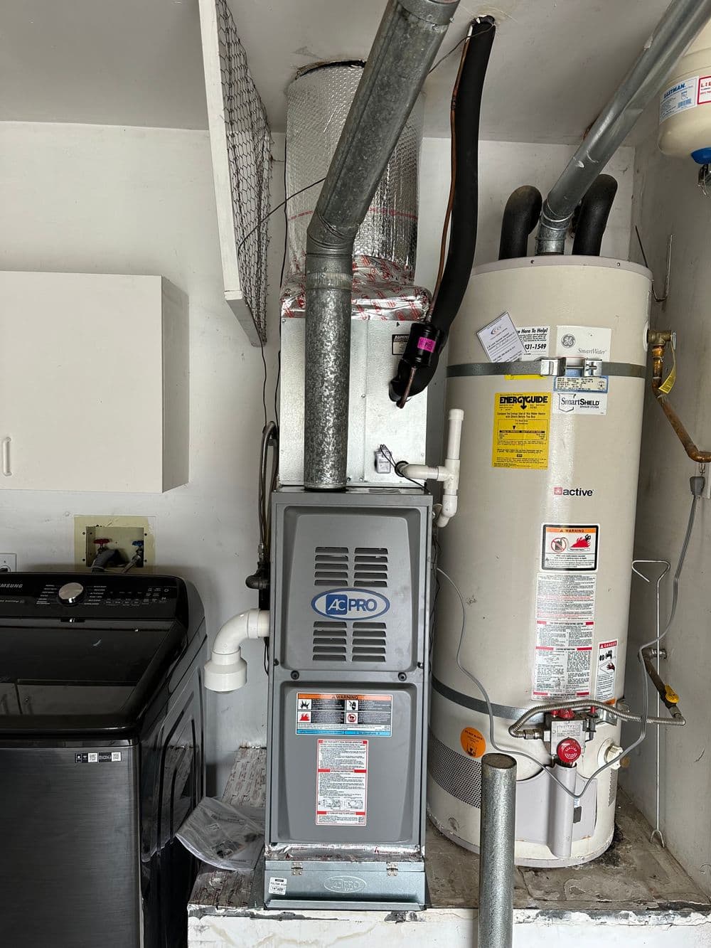 43Pro furnace next to a water heater in a utility room with washer and dryer.