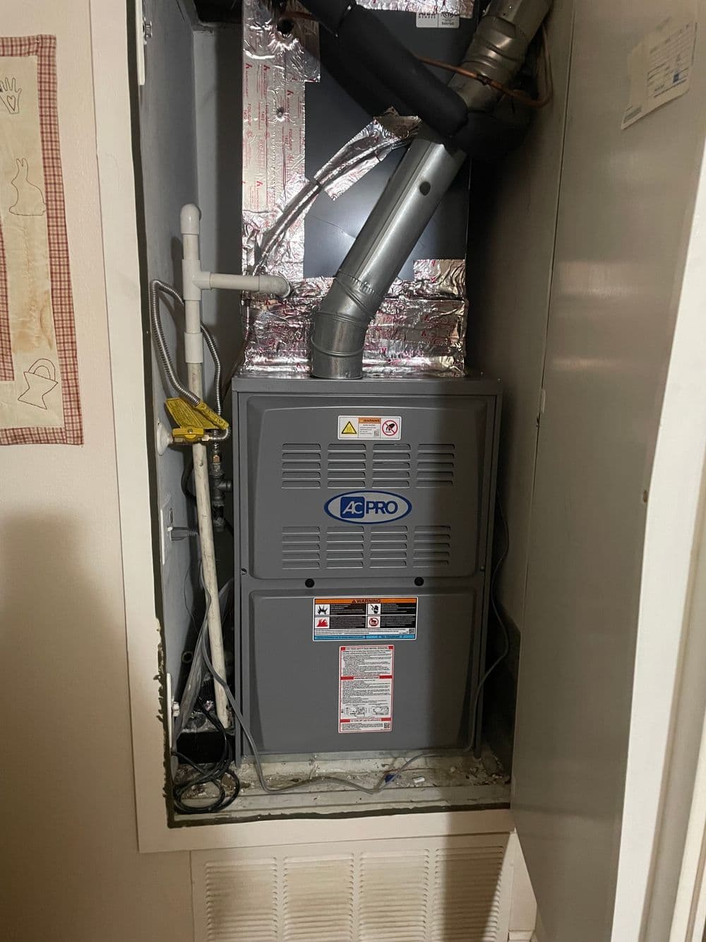 A Pro HVAC system installed in a compact utility closet with ductwork and insulation.